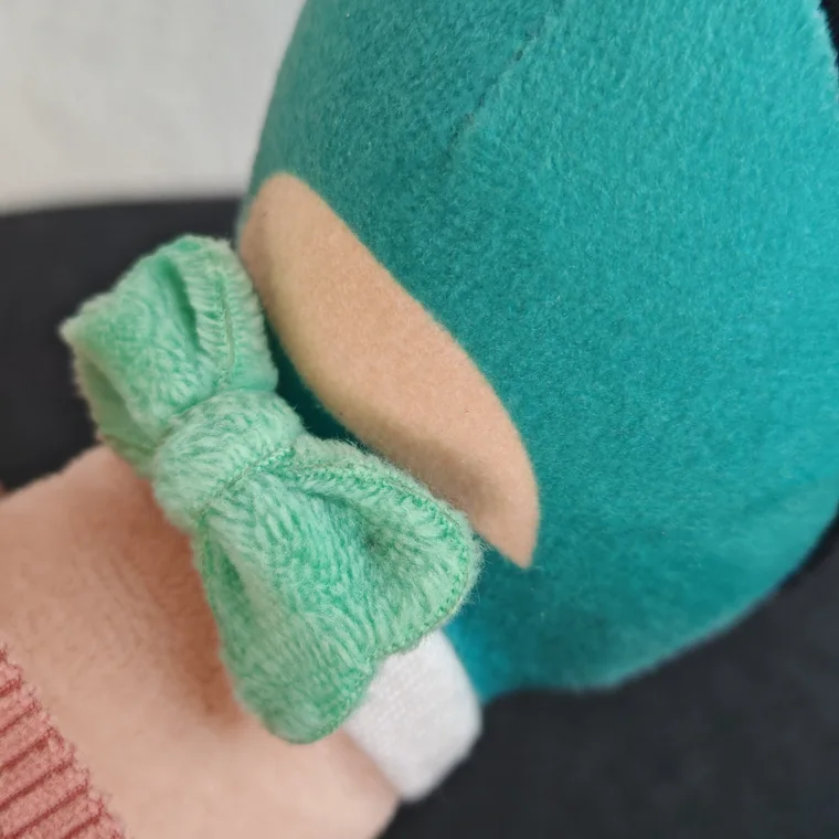 Photo macro d’un nœud vert sur la chaussure de Lotti, avec Kobi en arrière-plan